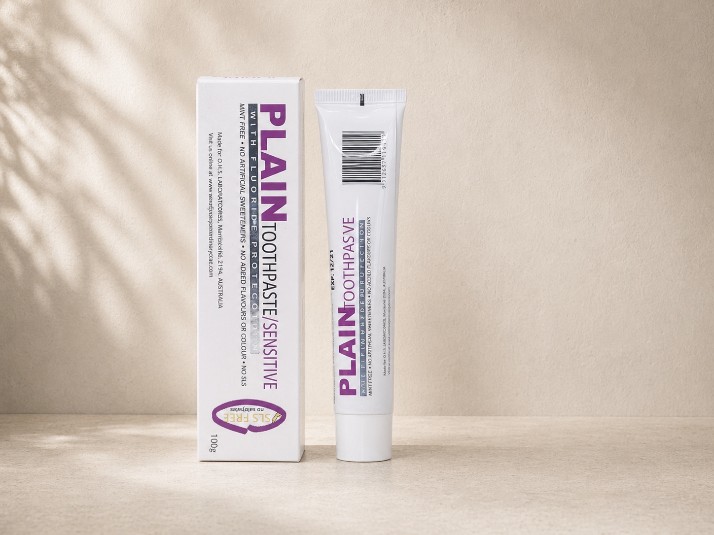 Plain Toothpaste Sensitive 100g carton and tube on a stone surface